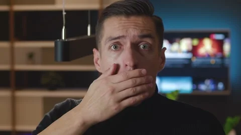 Portrait of scared man bulging eyes and covering mouth in fright reacting on Stockbeeldmateriaal 144038117