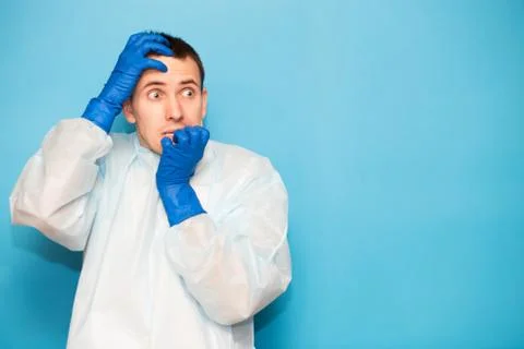 Portrait of scared man in protective suitt, medical mask and gloves against v Stock Photos