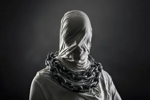 Portrait of a scary ghost with chains over dark misty background 写真素材