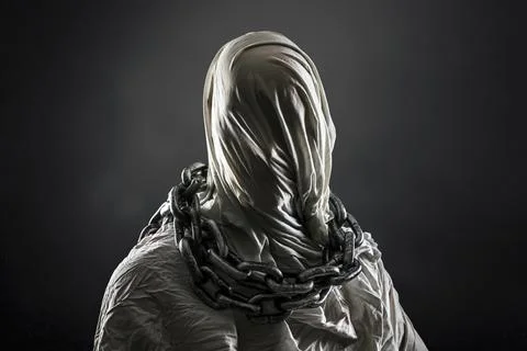 Portrait of a scary ghost with chains over dark misty background Stock Photos