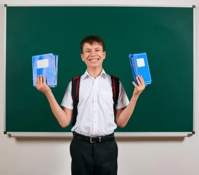 Portrait of a school boy posing with backpack and school supplies, blackboard Stock Photos