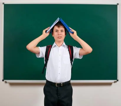 Portrait of a school boy posing with backpack and school supplies, blackboard Stock Photos