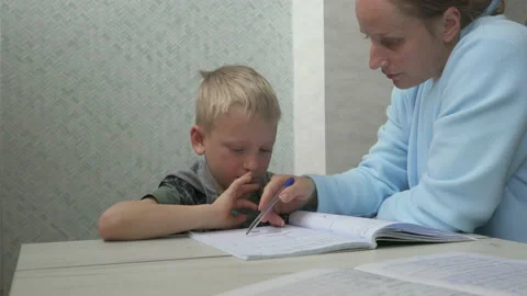 Portrait school kid siting on table doing homework, home schooling Stock Footage 171080836