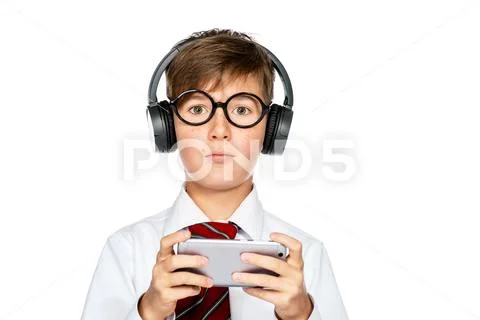 Portrait of a schoolboy playing computer game. Headphones, gadgets. Education Stock Photos