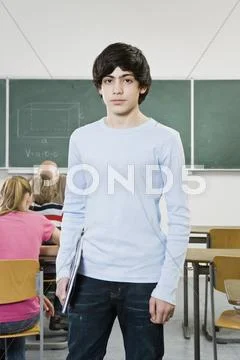 Portrait of a schoolboy standing in a classroom Stock Photos