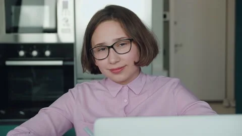 Portrait. Schoolgirl doing homework using laptop while sitting at home in the Stock Footage 157979383