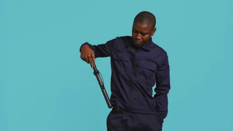 Portrait of security agent removing baton from belt to secure assigned post Stock Footage 277959809