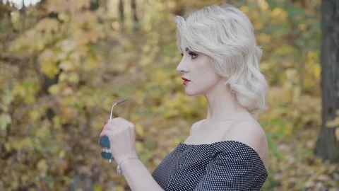Portrait of seductive blonde with red lips puts on sunglasses 스톡 동영상 124731095