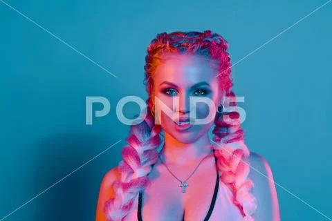 Portrait of seductive young European woman surrounded by evening neon lights Stock Photos