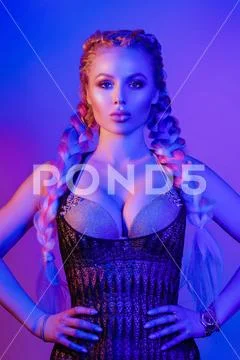 Portrait of seductive young European woman surrounded by evening neon lights Stock Photos