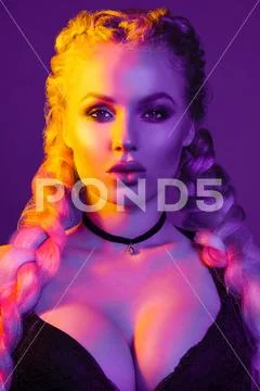 Portrait of seductive young European woman surrounded by evening neon lights Stock Photos