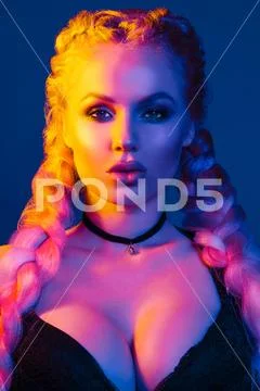 Portrait of seductive young European woman surrounded by evening neon lights Stock Photos