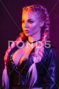 Portrait of seductive young European woman surrounded by evening neon lights Stock Photos