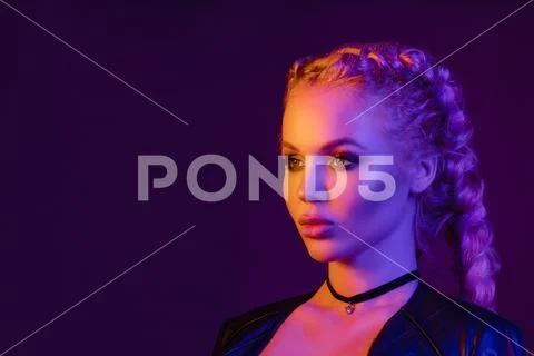 Portrait of seductive young European woman surrounded by evening neon lights Stock Photos