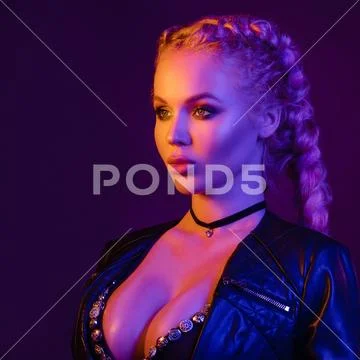 Portrait of seductive young European woman surrounded by evening neon lights Stock Photos