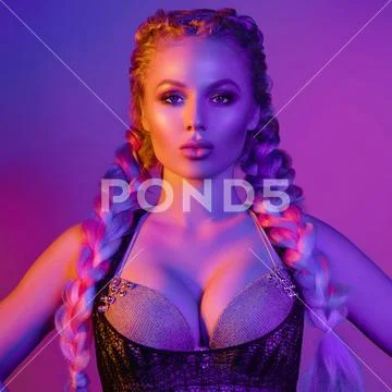 Portrait of seductive young European woman surrounded by evening neon lights Stock Photos