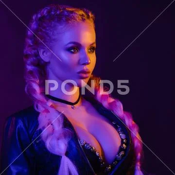 Portrait of seductive young European woman surrounded by evening neon lights Stock Photos