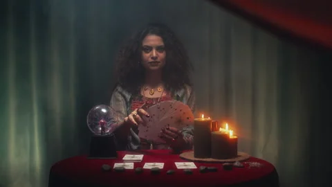 Portrait of Seer with Tarot Cards Deck Sitting at Table with Burning Candles Stock Footage 253179602