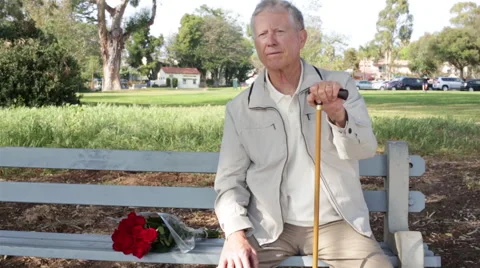 Portrait of a Senior Elderly Man Sitting on a Bench with Roses Stock Footage 48339891