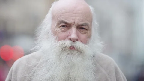 Portrait of senior man with a beard looking to camera with a serious expression Video stock 92449606