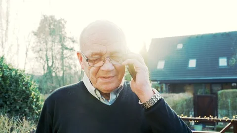 Portrait of senior man having conversation on mobile phone outside Stock Footage 104605311