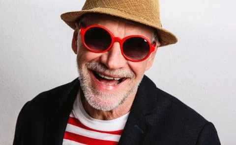 Portrait of a senior man with red sunglasses in a studio, headshot. Stock Photos