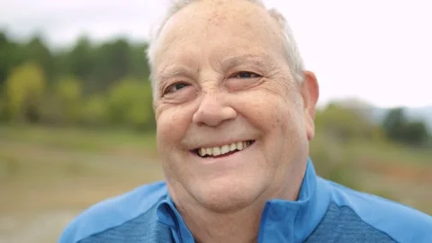 Portrait of senior man smiling on camera outdoor in mountain forest Stock Footage 168250793
