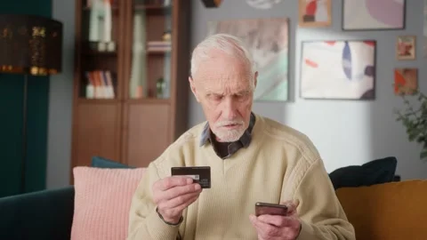 Portrait of senior old man using phone for online shopping purchase, holding in Stock Footage 148232923