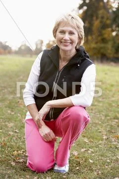 Portrait Of Senior Woman Crouching In The Park Stock Photos