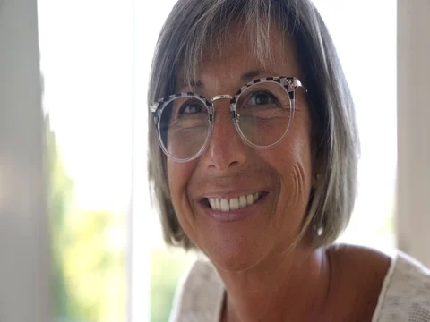 Portrait of senior woman with eyeglasses working on desktop Stock Footage