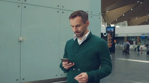 Portrait of serious 40s man checking the time on the phone while waiting for his Stock Footage 108868866
