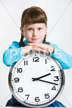 Portrait of serious girl with clock looking at camera Stock Photos