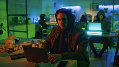 Portrait of Serious Hacker Sitting at Office Desk with Laptop at Night Time Stock Footage 299238557