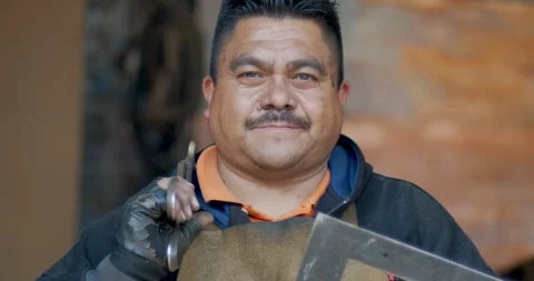 Portrait of a serious Hispanic man looking at the camera holding tools Stock Footage 102721169