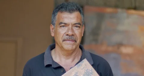 Portrait of a serious looking hispanic man holding a piece of copper Video stock 102721046