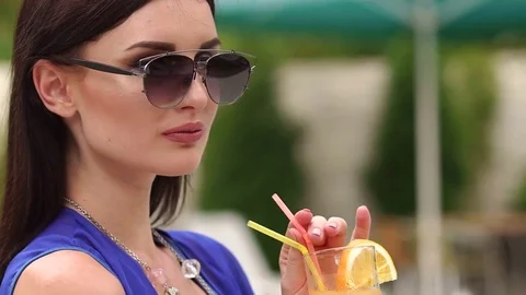 Portrait of sexy girl with a cocktail next to pool Stock Footage
