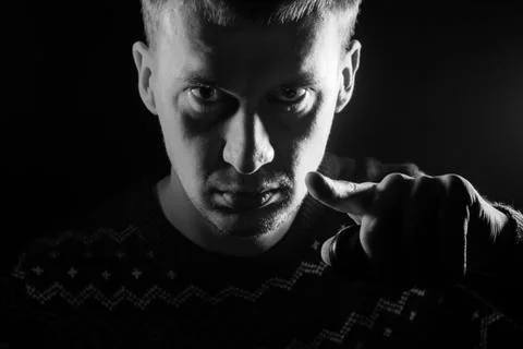 Portrait of a short-haired boy with a shadow on a serious face dressed in a s Stock Photos