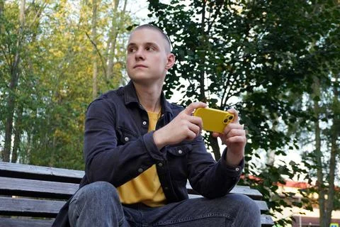 Portrait of a short-haired guy using a smart phone. a young adult, a student, an Stock-Fotos