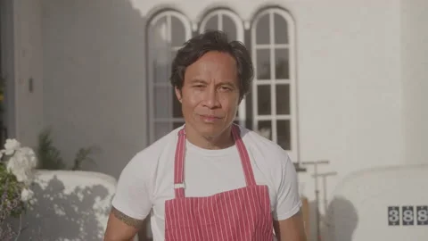 Portrait shot of Asian Man Doing Yard Work outdoors and looking into camera Stock Footage 208782653