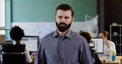 Portrait shot of handsome young man with a beard looking and smiling into the Stock Footage 82445258