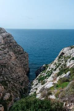 Portrait shot looking down cliffs on the Maltese south coast near blue grotto Stock Photos