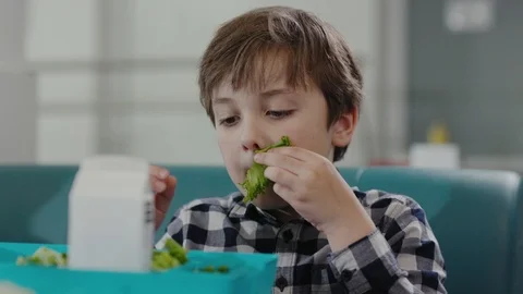 Portrait of a silly funny boy placing leaves of salad on his face like a Stock Footage 111546435