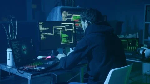 Portrait of sinister computer hacker working with codes breaking into security 스톡 사진