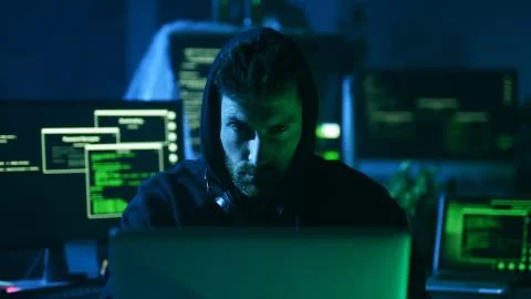 Portrait of sinister computer hacker working with codes breaking into security Stock Photos
