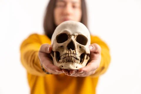 Portrait of a skeleton's skull model held by caucasian man wearing yellow Stock Photos