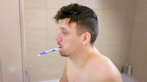Portrait of sleepy man brushes teeth and falls asleep with toothbrush in mouth. Stock Footage 119155204
