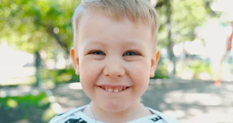 Portrait of small boy looking at camera, laughing and smiling. Cute blue-eyed Stock Footage 132158003