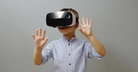 Portrait of the small funny boy using VR glasses and touching something in front Stock Footage 82865226
