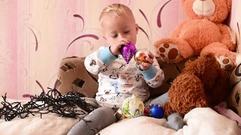 Portrait of small kid boy plays with christmas balls and garland .Magic vibe of Video stock 219480198