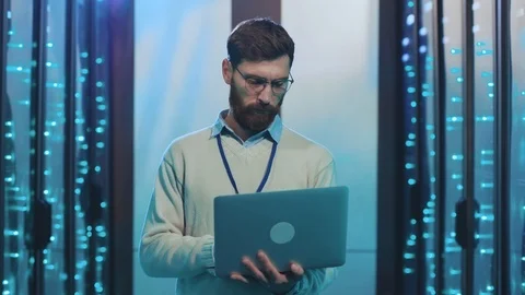 Portrait of smart bearded IT administrator working on notebook standing in Stock-Footage 119233045